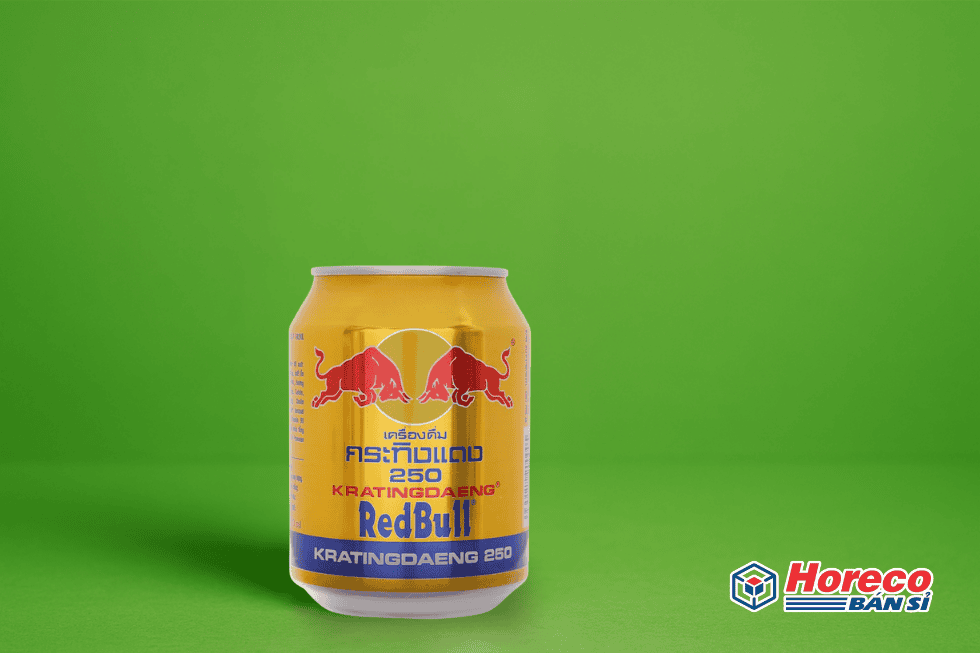 Hàng Tiêu Dùng HORECO https://horeco.vn Lon Red Bull trên nền xanh lá cây sáng, thể hiện năng lượng và an toàn.