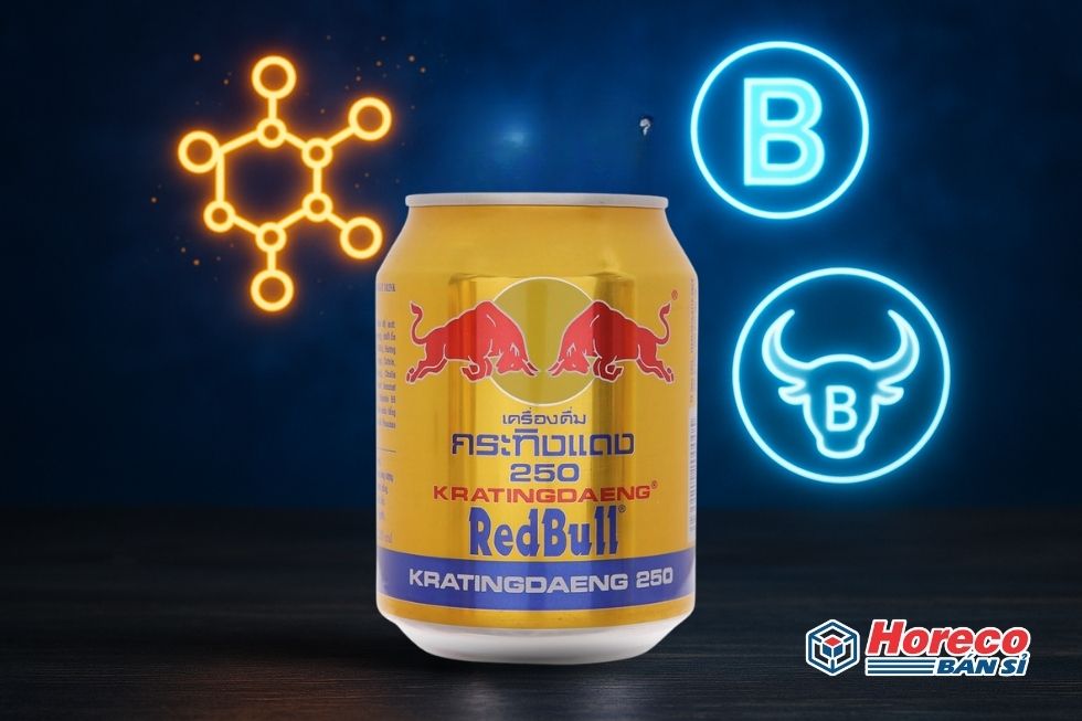 Hàng Tiêu Dùng HORECO https://horeco.vn Lon Red Bull cùng các biểu tượng đại diện cho caffeine, taurine, và vitamin B.